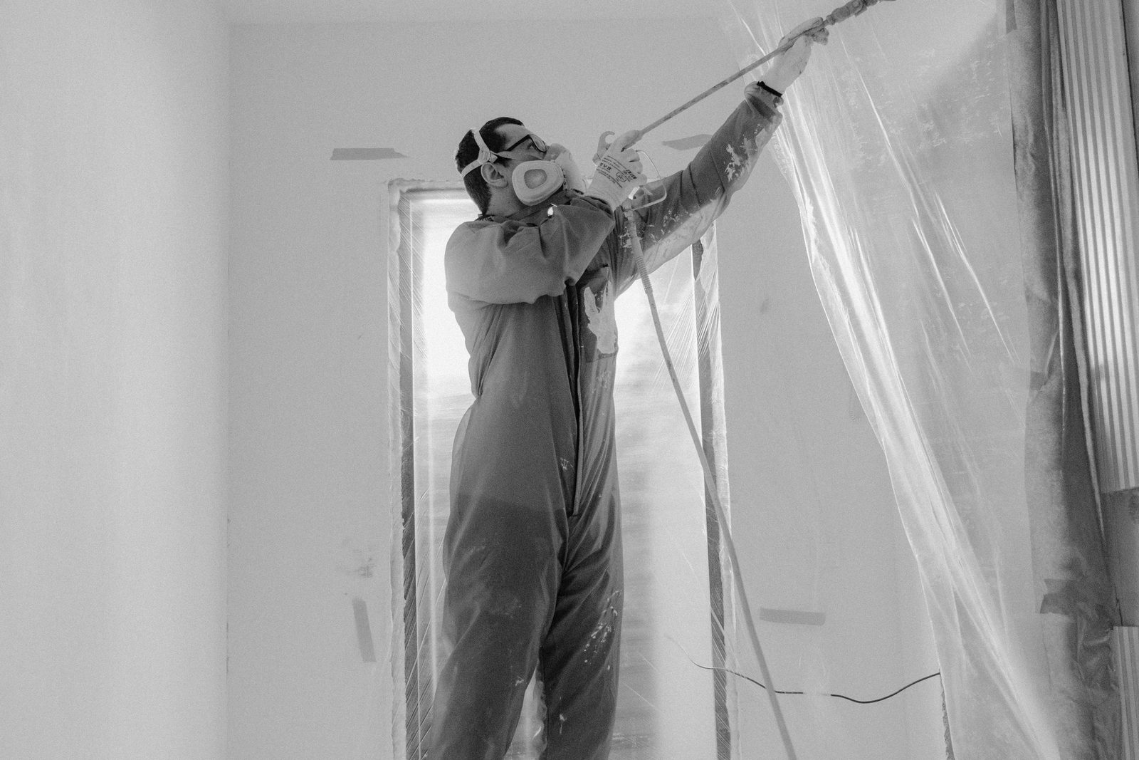 Operative in a respirator spraying plaster onto a wall